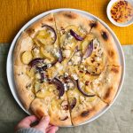 pizza met aardappel, rode ui, gorgonzola en spicy honing